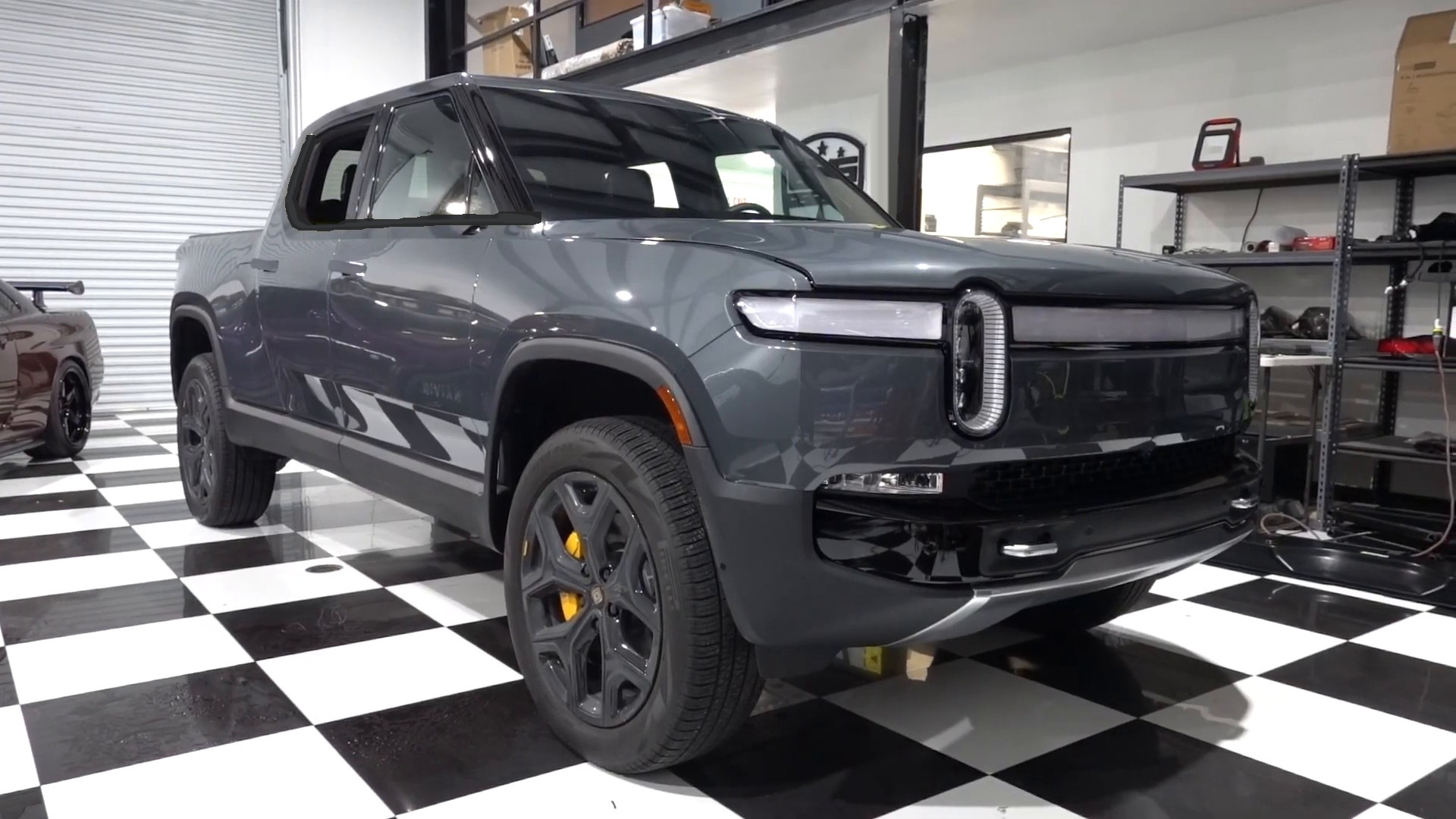 Gray Rivian R1T electric pickup inside the EVS Motors shop in Houston, a Rivian Service Partner