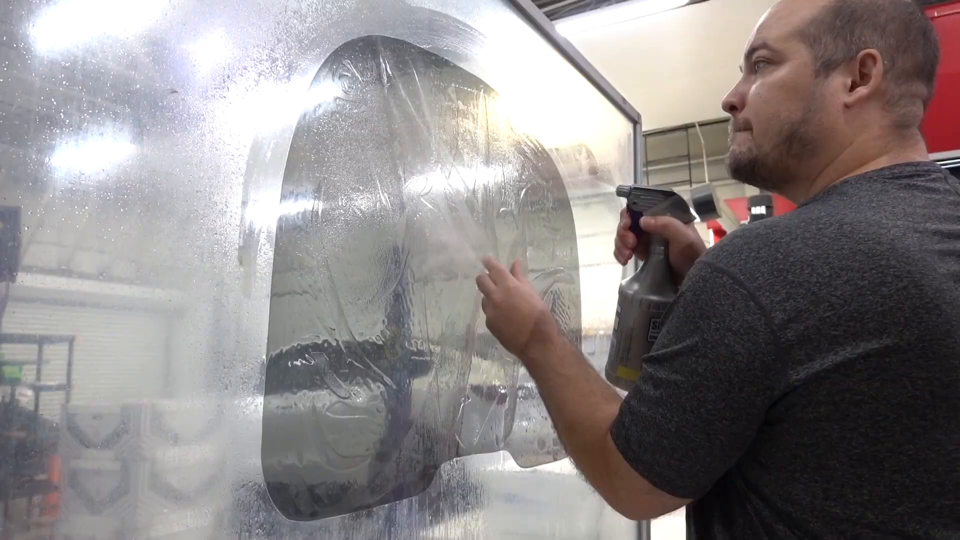 Installer applying window film to a side window at EVS Motors